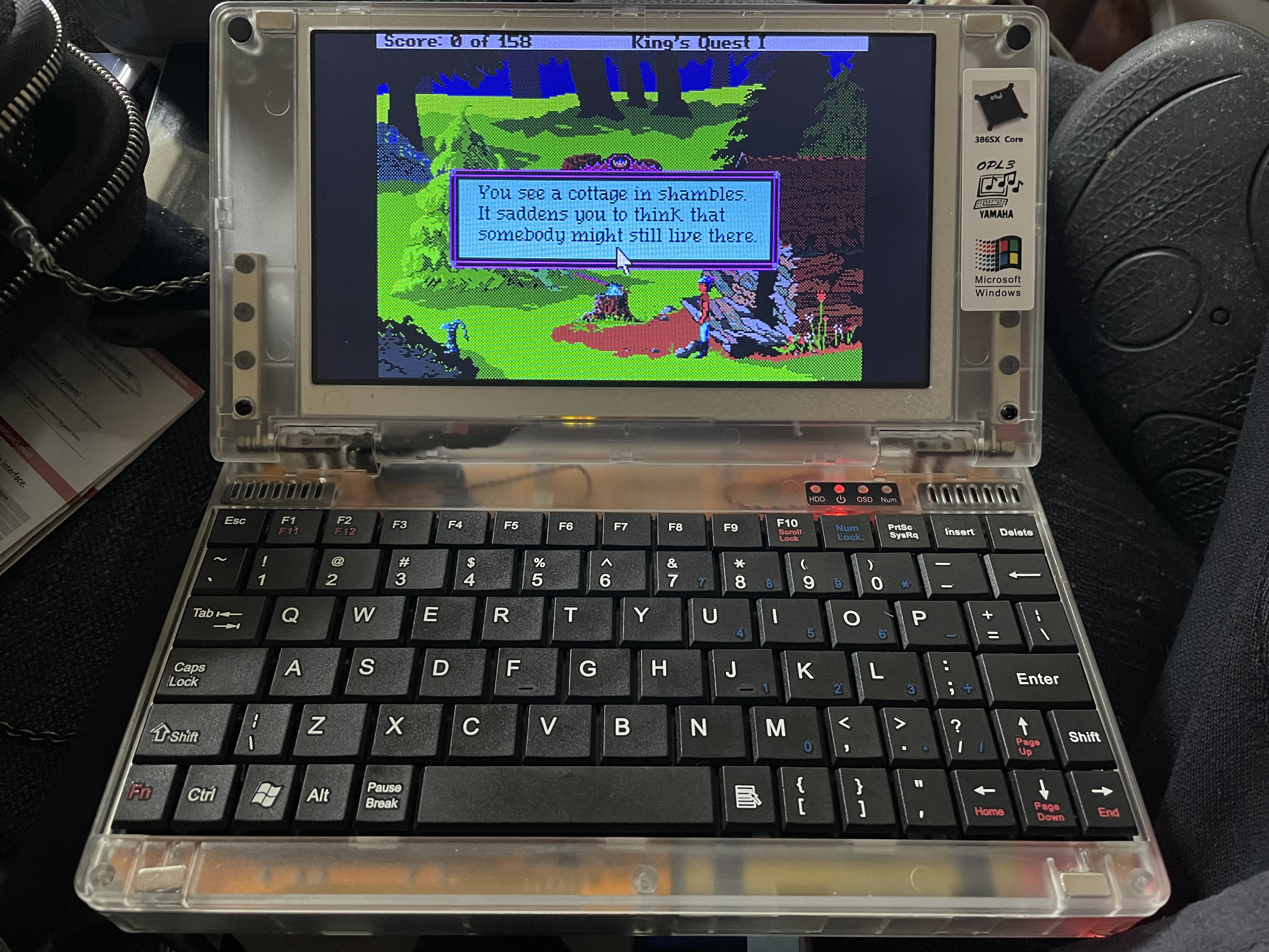 King’s Quest 1 VGA running on a Pocket 386 laptop. The screen shows Graham outside a dilapidated cottage in a forest. 