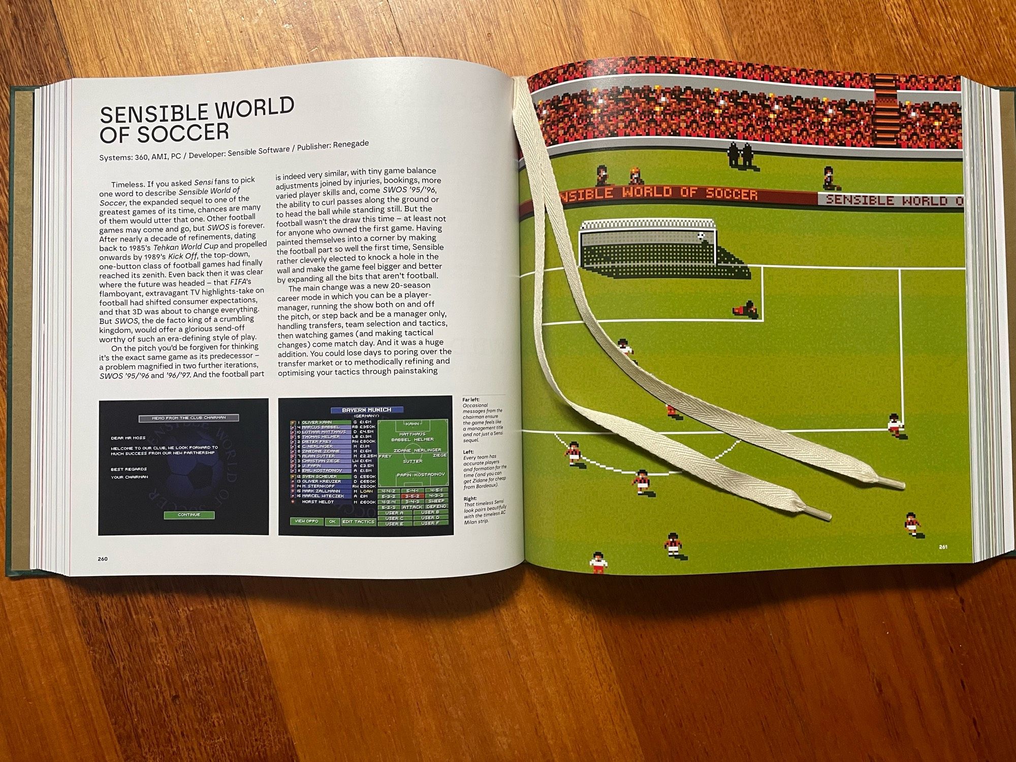 A photo of a spread from the book, showing text and screenshots about Sensible World of Soccer. Also visible: shoelace bookmark ribbons.